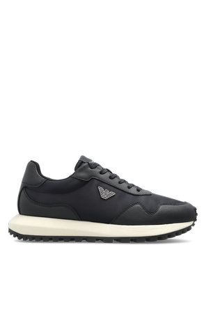 Sports shoes with a logo-shaped applique