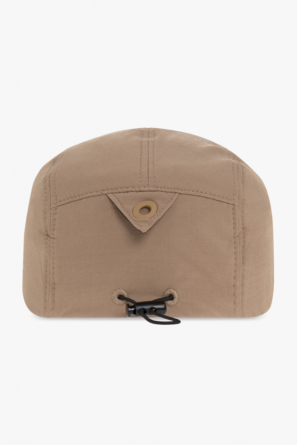 White Mountaineering Beżowa czapka z daszkiem . Z boku ozdobiona nadrukowanym logo. Z tyłu ściągana trokami