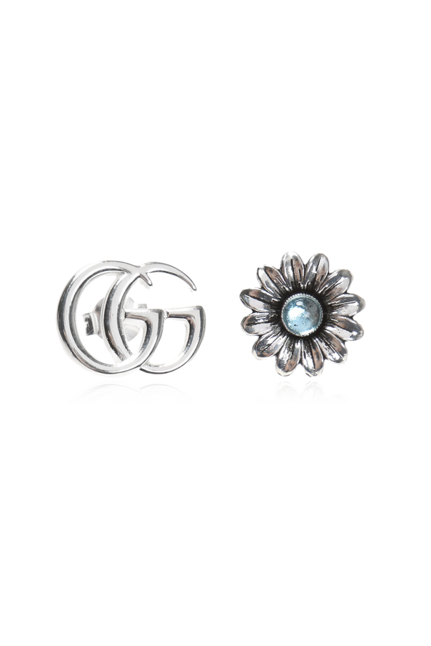 Silver earrings in the shape of a logo and a flower. od Gucci