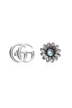 Silver earrings in the shape of a logo and a flower.